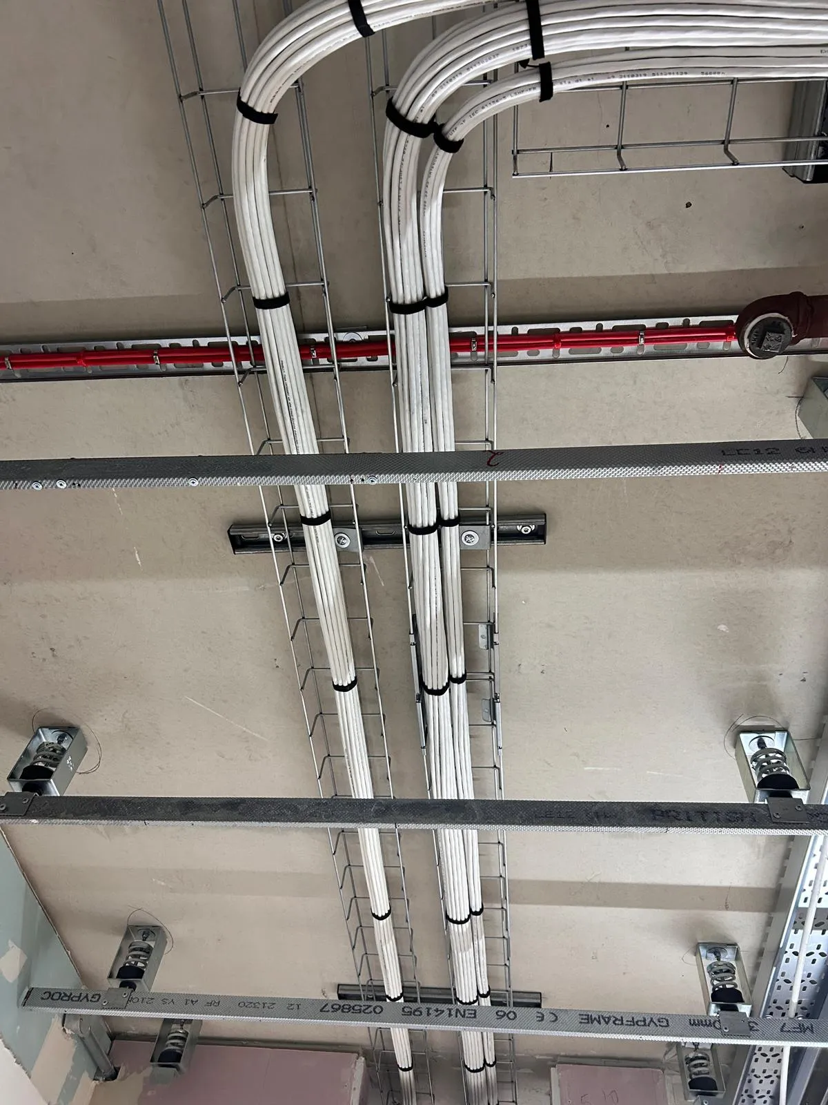 Neat Cat6 cabling runs in metal basket tray, ceiling infrastructure installation