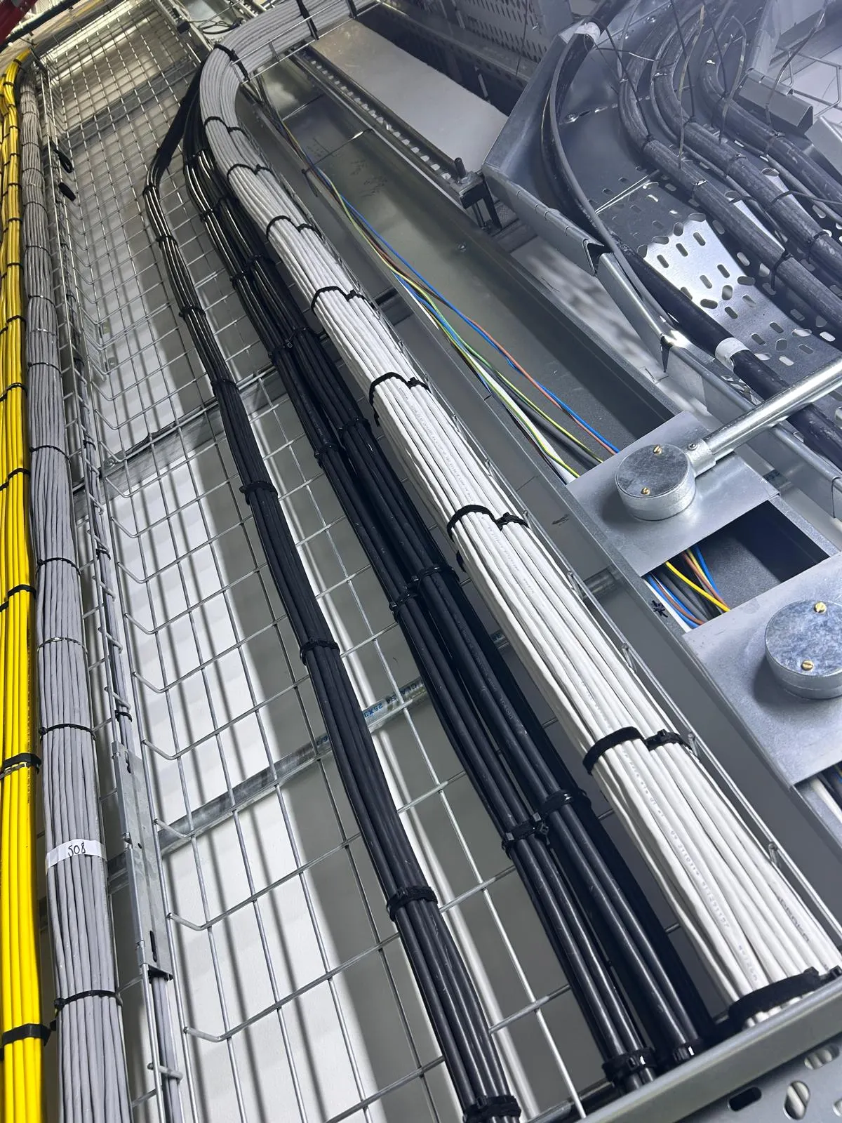Organised copper and fibre cable bundles in basket tray and trunking