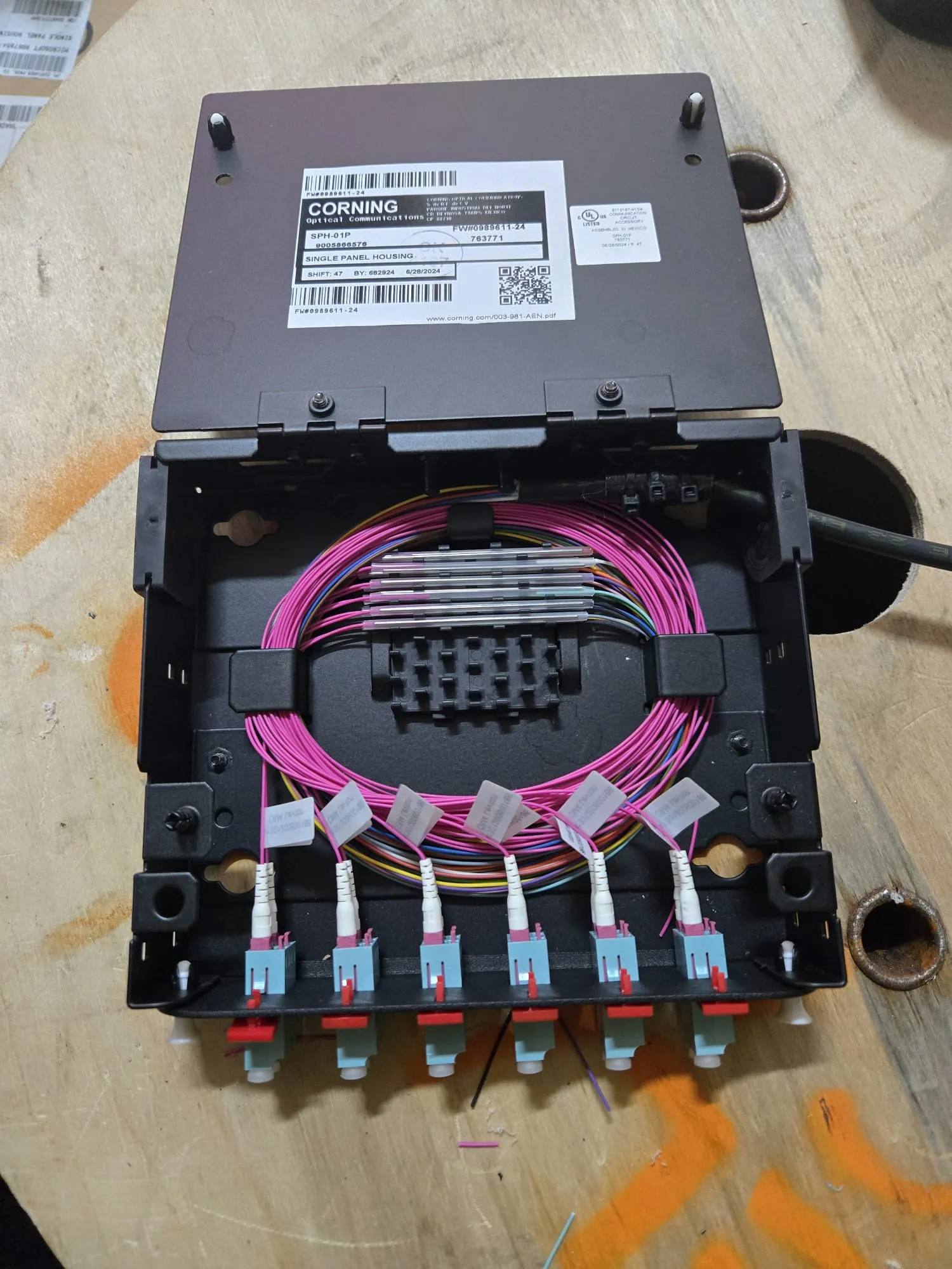 Fibre optic splice enclosure with neatly coiled strands and LC terminations